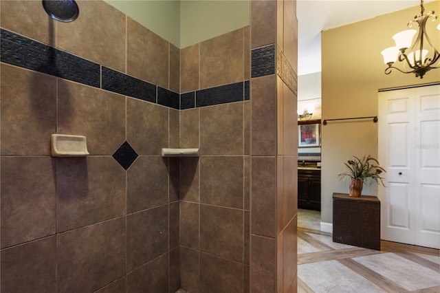 bathroom featuring tiled shower and an inviting chandelier