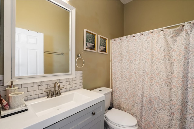 bathroom with vanity, backsplash, and toilet