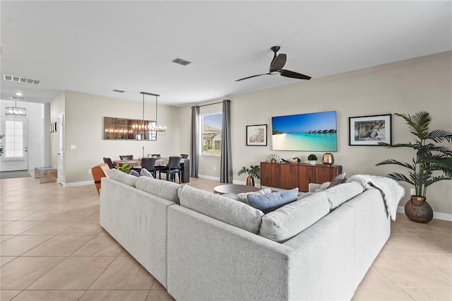 living room featuring ceiling fan with notable chandelier and light tile patterned floors