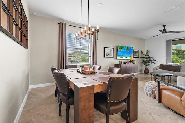 tiled dining space with ceiling fan with notable chandelier and plenty of natural light