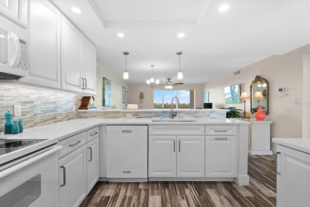 kitchen with ceiling fan, sink, kitchen peninsula, white appliances, and white cabinets