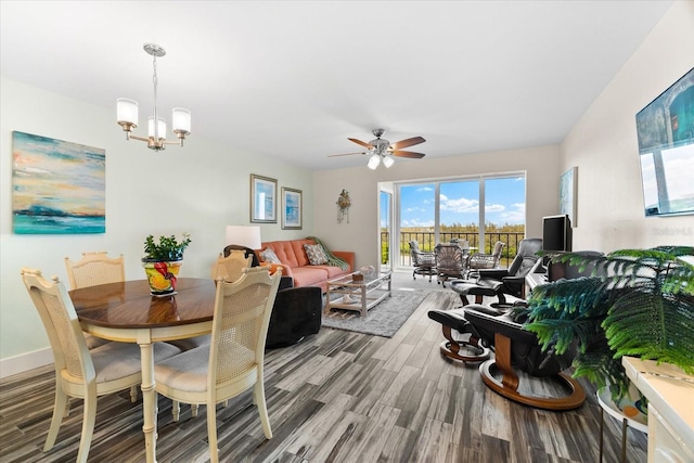 dining space with hardwood / wood-style floors and ceiling fan with notable chandelier