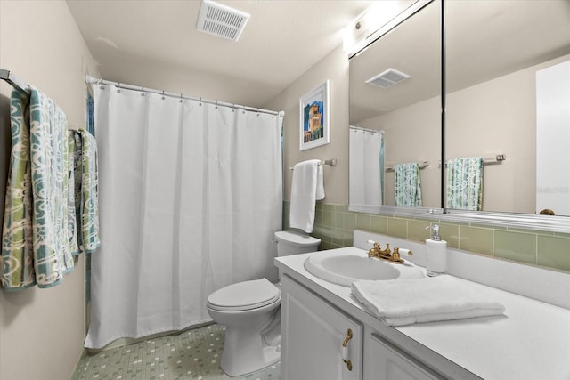 bathroom featuring backsplash, vanity, and toilet