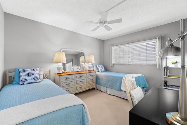 carpeted bedroom featuring ceiling fan and a textured ceiling