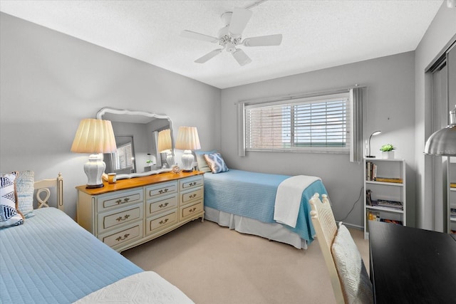 carpeted bedroom featuring a textured ceiling, a closet, and ceiling fan