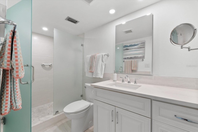 bathroom with vanity, toilet, and a shower with door