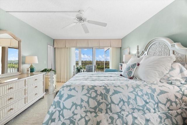 carpeted bedroom featuring access to exterior, a textured ceiling, multiple windows, and ceiling fan