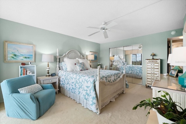 bedroom with light colored carpet, a closet, and ceiling fan