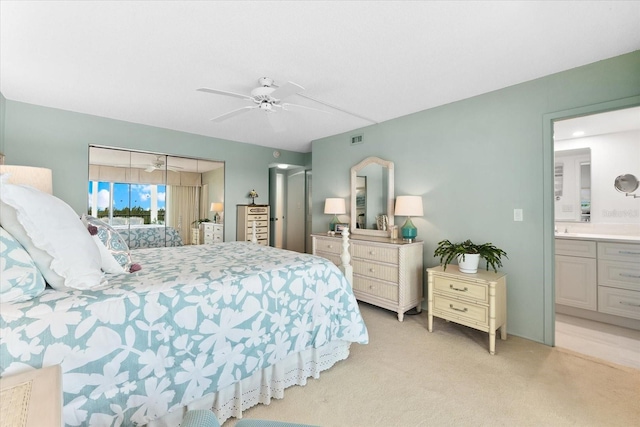 carpeted bedroom featuring ensuite bathroom and ceiling fan