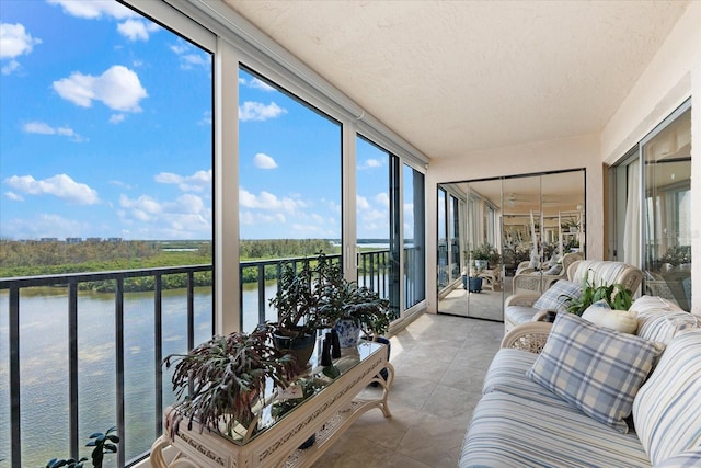 sunroom featuring a water view