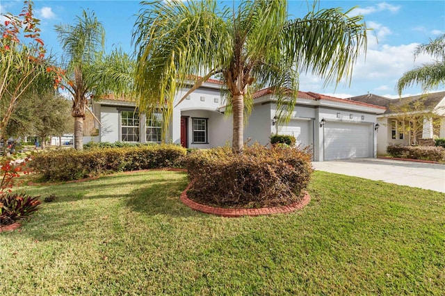 mediterranean / spanish-style house featuring a front yard and a garage