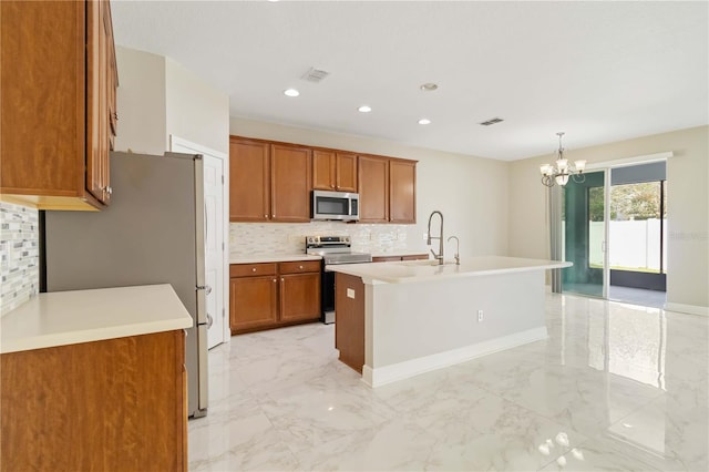 kitchen featuring stainless steel appliances, sink, a center island with sink, a chandelier, and hanging light fixtures