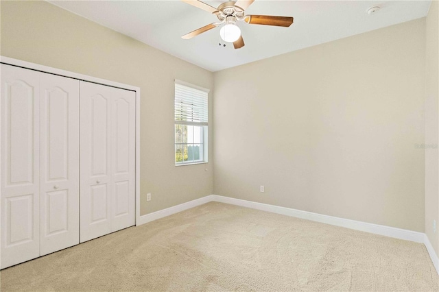 unfurnished bedroom featuring carpet flooring, ceiling fan, and a closet