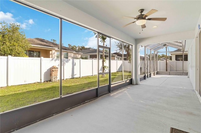 unfurnished sunroom with ceiling fan