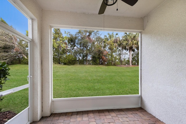 unfurnished sunroom featuring ceiling fan