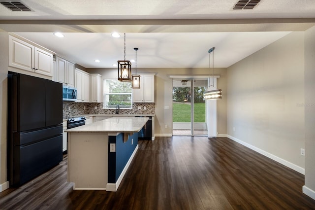 kitchen featuring backsplash, decorative light fixtures, a kitchen island, and black appliances