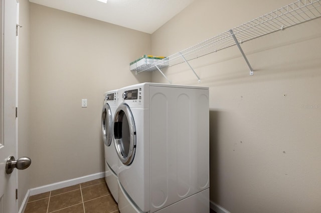 washroom featuring washing machine and clothes dryer and dark tile patterned flooring