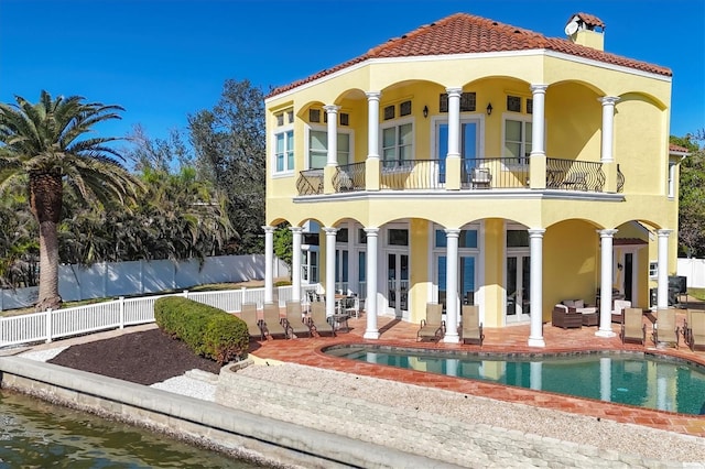 back of property featuring an outdoor living space, a patio area, a balcony, and french doors