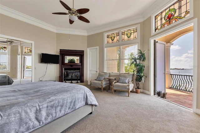 carpeted bedroom with ceiling fan, a water view, and ornamental molding