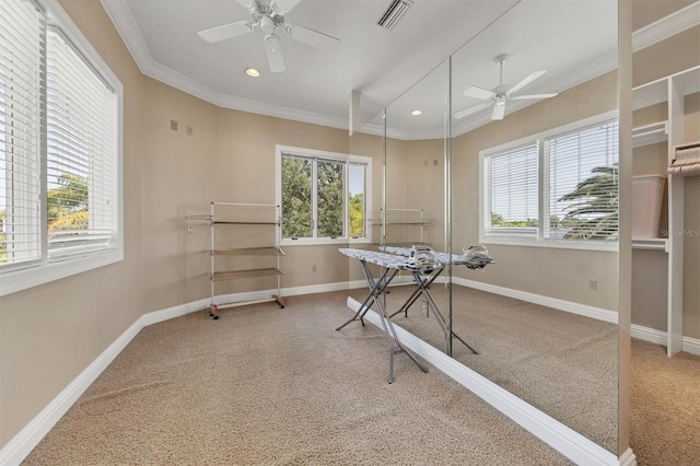 carpeted office space featuring ceiling fan and ornamental molding