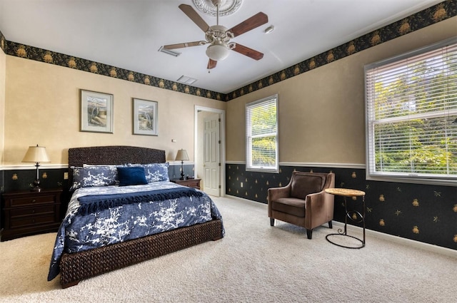 carpeted bedroom with ceiling fan and multiple windows