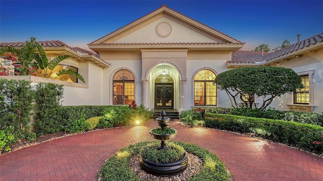 exterior entry at dusk featuring french doors