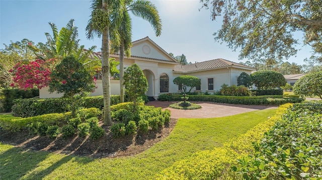 mediterranean / spanish home with a front lawn