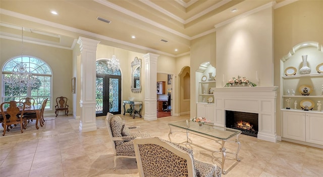 living room with a notable chandelier, built in features, ornamental molding, and a towering ceiling