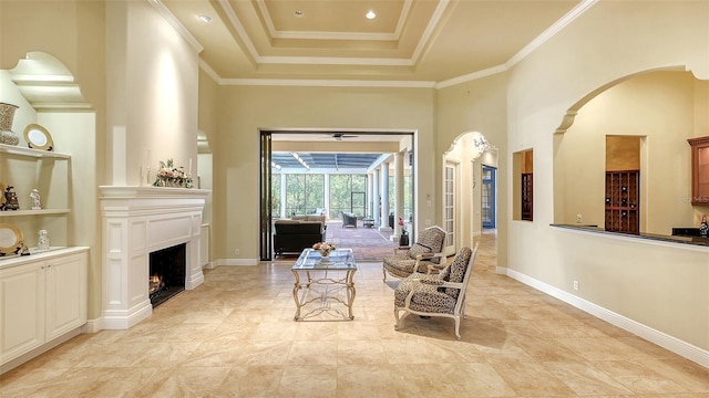 sitting room featuring ornamental molding, a towering ceiling, and a tray ceiling