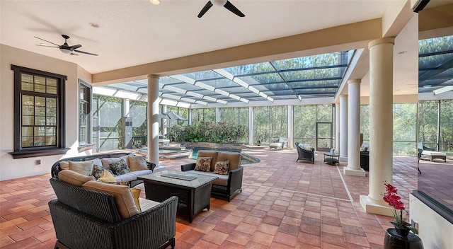 view of patio with ceiling fan, a swimming pool with hot tub, a lanai, and an outdoor living space with a fire pit