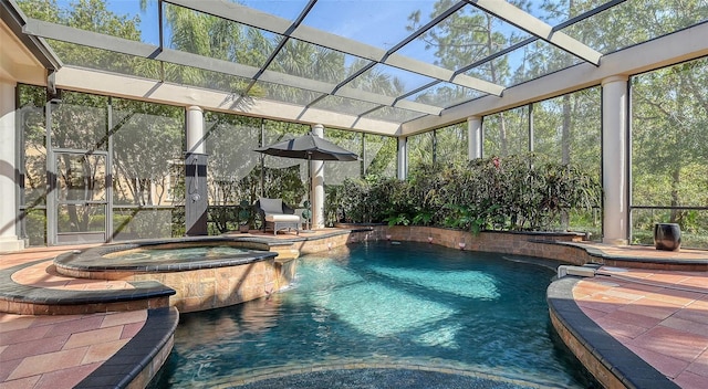 view of pool featuring glass enclosure, an in ground hot tub, a patio area, and pool water feature