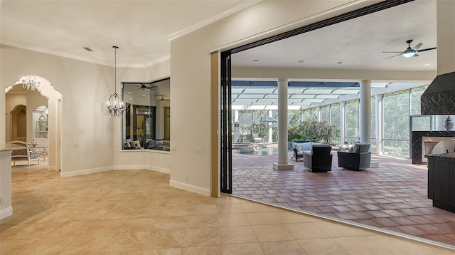 doorway to outside with a premium fireplace, crown molding, light tile patterned floors, and a healthy amount of sunlight