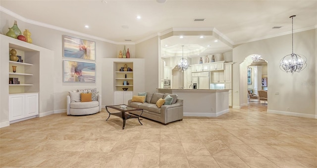 living room with built in shelves, crown molding, and an inviting chandelier