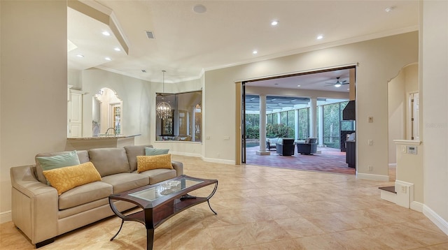 living room featuring ceiling fan with notable chandelier and ornamental molding