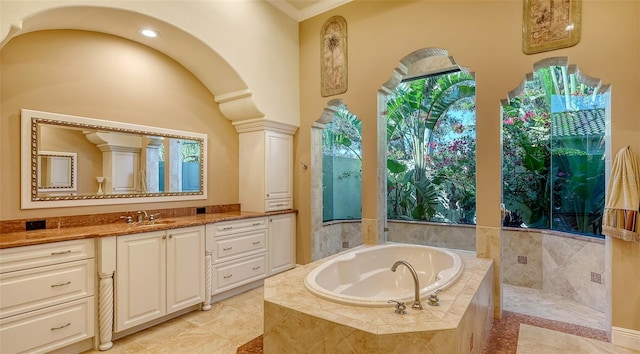 bathroom featuring tiled bath and vanity