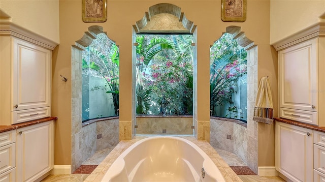 bathroom with tiled tub and vanity