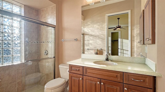 bathroom featuring an enclosed shower, ceiling fan, toilet, and vanity