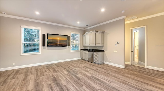 unfurnished living room with light hardwood / wood-style flooring, crown molding, and sink