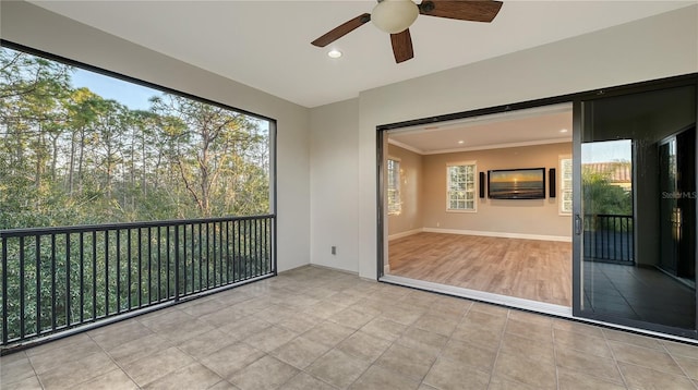 unfurnished sunroom with ceiling fan