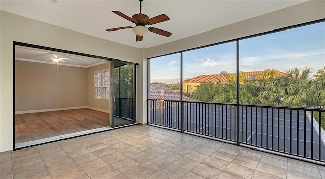 unfurnished sunroom with ceiling fan