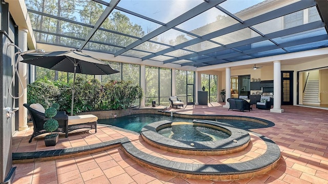 view of pool featuring ceiling fan, glass enclosure, an in ground hot tub, and a patio