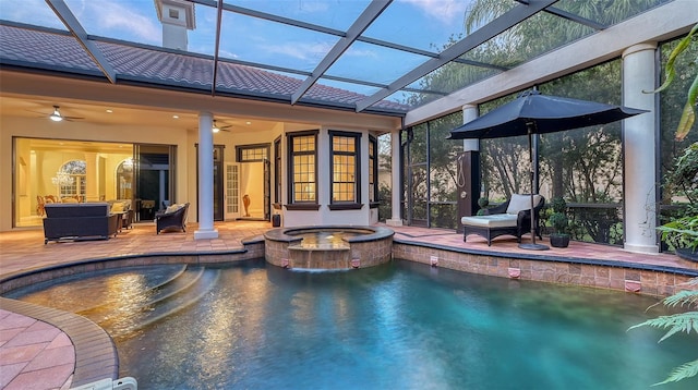 view of pool featuring ceiling fan, a patio area, an in ground hot tub, and glass enclosure