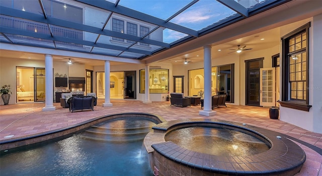 exterior space with outdoor lounge area, ceiling fan, a lanai, an in ground hot tub, and a patio area