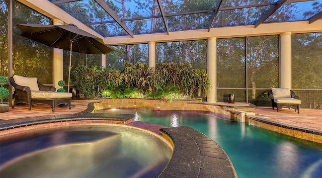 view of pool with an in ground hot tub, glass enclosure, and a patio area