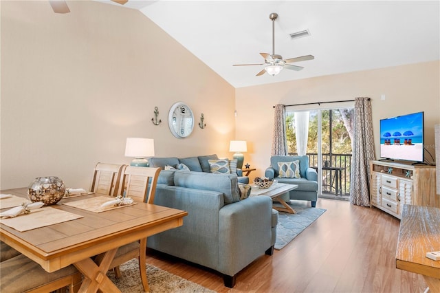 living room with ceiling fan, lofted ceiling, and light hardwood / wood-style flooring