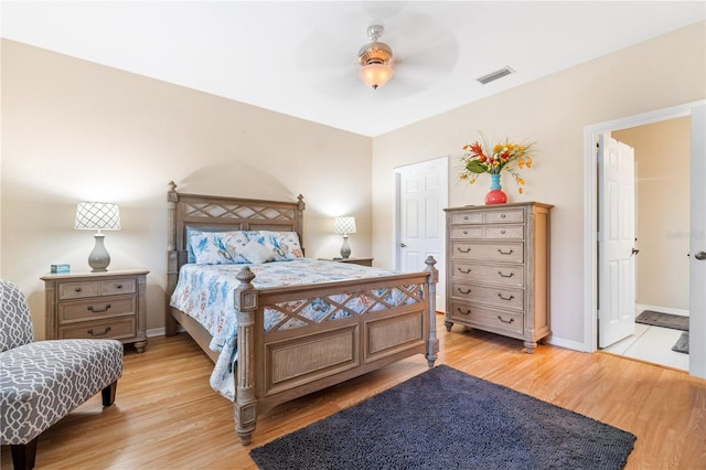 bedroom with ceiling fan, light wood-type flooring, and ensuite bathroom