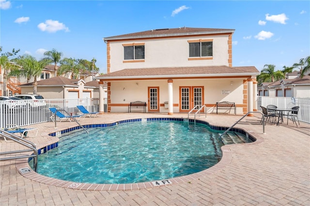 view of pool with french doors and a patio