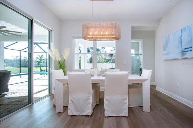 dining area featuring wood-type flooring and a notable chandelier