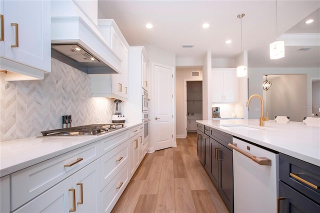 kitchen with white cabinetry, hanging light fixtures, stainless steel appliances, and custom range hood