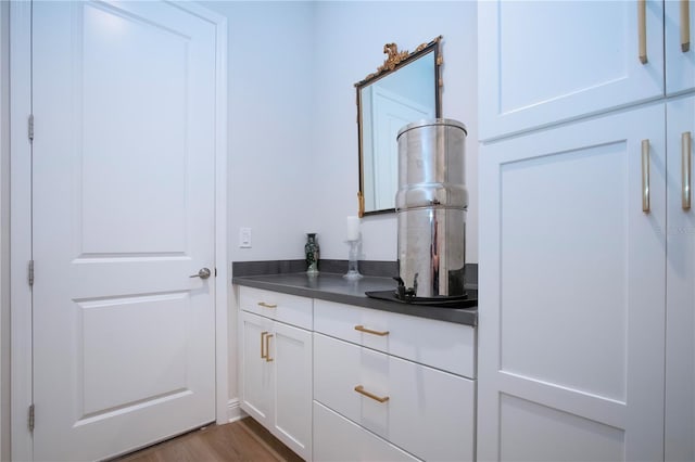 bar featuring white cabinetry and dark wood-type flooring